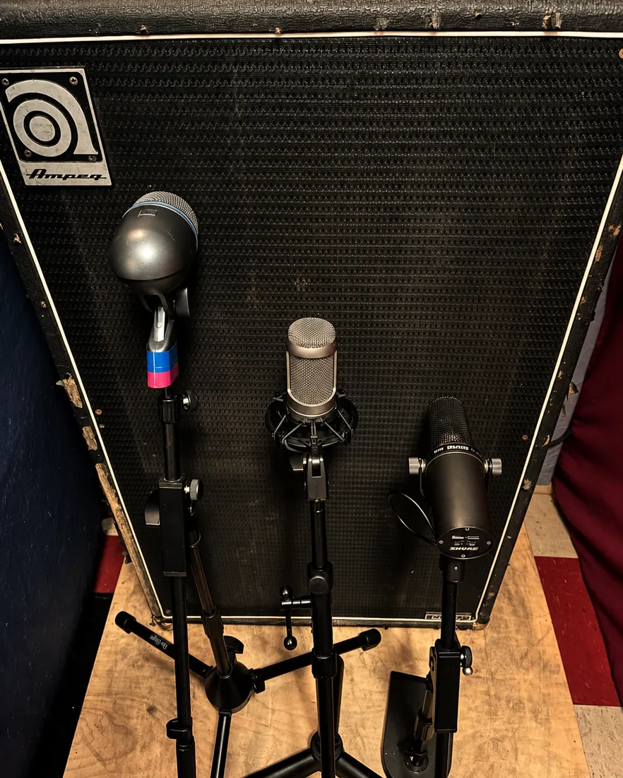 Three microphones placed on an Ampeg bass cabinet.